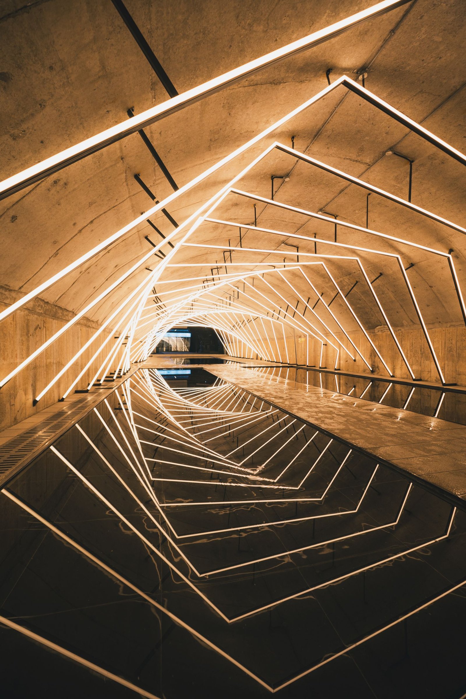 Illuminated geometric tunnel with reflections creating a sci-fi aesthetic atmosphere.